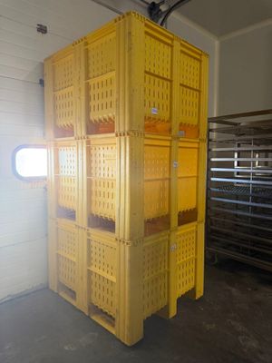 une grande caisse jaune au milieu d'une pièce
