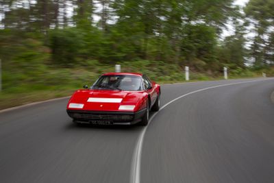 a red car that is driving down the road
