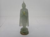 une petite statue de Bouddha posée sur une surface blanche