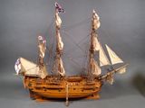a wooden model of a sailing ship on display