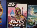three star wars games are on display on a black surface