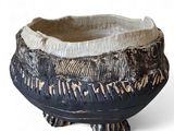 a black and white bowl on a stand on a white surface
