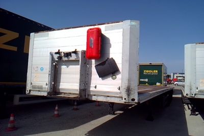 un camion blanc avec une borne d'incendie rouge à l'arrière