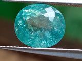un gros plan d'un diamant bleu tenu par une pince