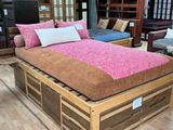 un lit recouvert d'un couvre-lit rose dans une chambre