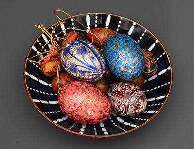 un bol rempli d'œufs de différentes couleurs posé sur une table