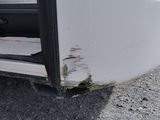 a close up of a white truck with a hole in the side of it