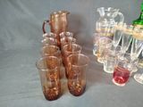 many glasses and a pitcher sitting on a table