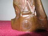 a bronze statue of a woman sitting on a table