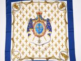 a blue and white square scarf with an image of a royal eagle