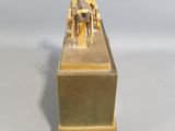 brass statue of a man riding a horse on top of a wooden box