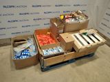 Plusieurs cartons contenant des articles divers sont posés sur une palette devant un mur.