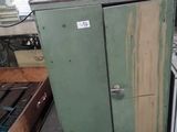 a green cabinet in the middle of a room with a stove