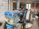 a blue tractor that is parked in a garage