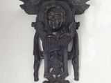 a wall clock that has a carved face on it