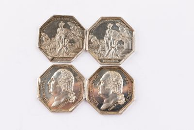 quatre pièces de monnaie britanniques différentes empilées les unes sur les autres sur une surface blanche