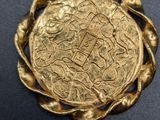 a close up of a gold coin on a black surface