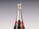 une bouteille de champagne avec une étiquette rouge sur fond blanc