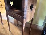 une chaise en bois dont le dossier est découpé en forme de cœur