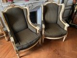 two black and white striped chairs sitting in front of a fireplace