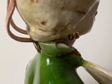 a green vase with a bird on top of it