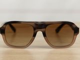 sunglasses on a wooden table with a white wall in the background
