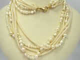 a close up of a necklace with pearls on a mannequin
