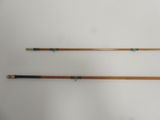 two old fishing rods on a white surface with a white background