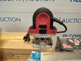a red and black electric router on a table next to a box