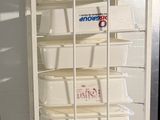 a white refrigerator with many shelves on it in a room
