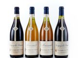 trois bouteilles de vin posées les unes à côté des autres sur une surface blanche