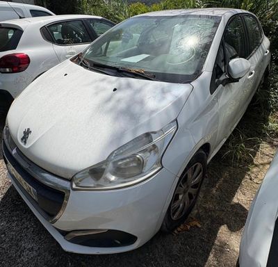 une petite voiture blanche garée sur un parking avec d'autres voitures