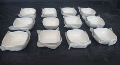 de nombreux bols blancs posés sur une table noire