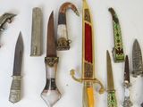 many different types of knives on a white surface