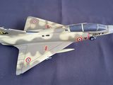 a model of a fighter jet sitting on a blue surface