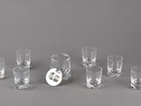 plusieurs verres à shot et une carafe posés sur une table