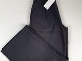 un pantalon noir posé sur une table blanche