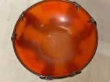 a small orange bowl sitting on a white surface
