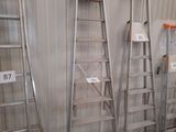 several ladders are lined up against a wall in a warehouse