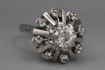une vieille bague sertie d'un diamant taillé, dont la pierre centrale est entourée de petits diamants