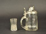 a glass cup and a glass pitcher on a table