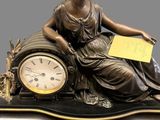 a statue of a woman sitting on top of a clock