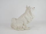 a white statue of a dog sitting on a white surface