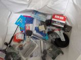 a white bag full of electronic items on a bed