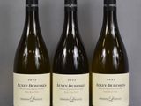 three bottles of wine are lined up on a table