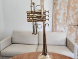 une trompette en laiton posée sur une table en bois dans un salon