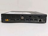 the back view of a small black computer on a white surface