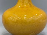 a yellow vase that is sitting on a table
