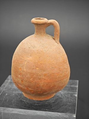 une image représentant un vase en argile posé sur un socle en marbre