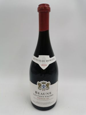 la bouteille de vin rouge est posée sur une surface blanche